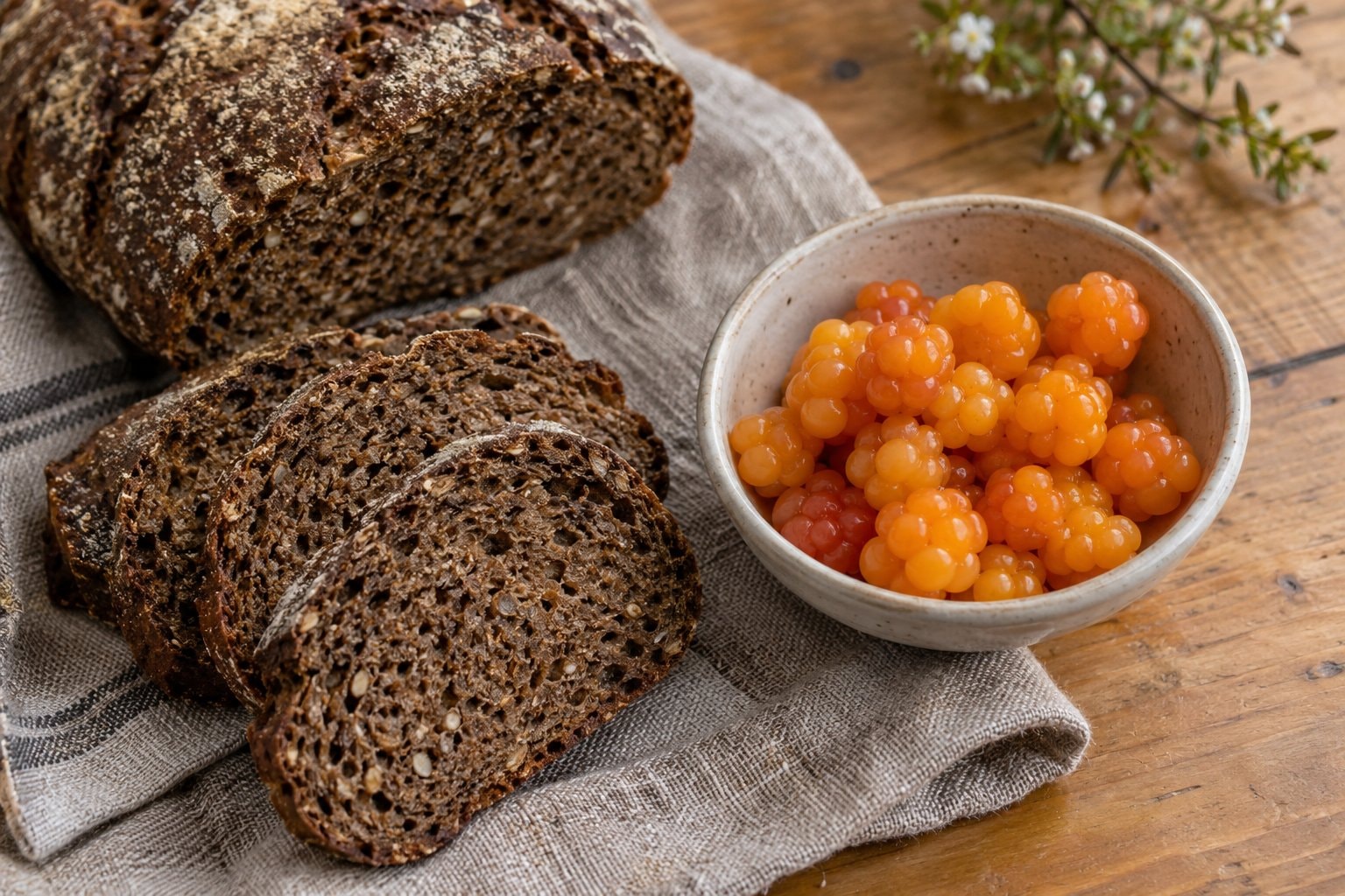 Dark rye bread and amber berries on a plain kitchen table